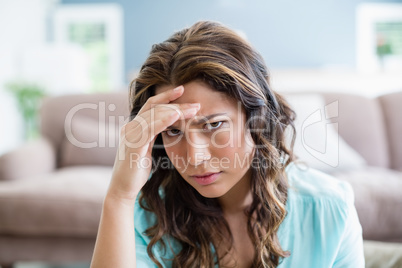 Portrait of tensed woman sitting in living room