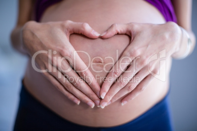 Mid section of pregnant woman touching her belly in ward