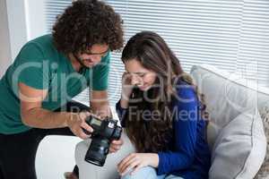 Photographer and female model reviewing captured photos in digital camera