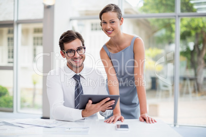 Business executives holding digital tablet at conference centre