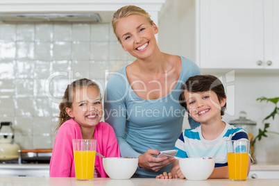 Portrait of mother and kids standing in kitchen