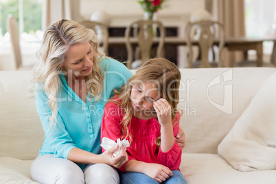 Mother comforting her daughter in living room