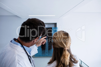 Male and female doctor discussing over x-ray report