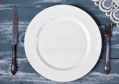 Empty white plate with knife and fork