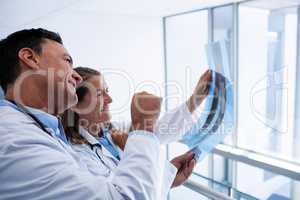 Male and female doctor discussing over x-ray report