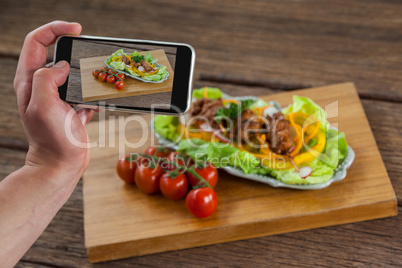 Photographer clicking a picture of food using smartphone