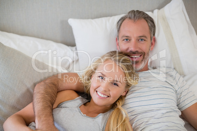 Happy couple relaxing on bed in bedroom