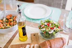 Bowl of salad and olive oil on dinning table