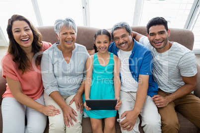 Multi-generation family using digital tablet in living room at home