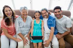 Multi-generation family using digital tablet in living room at home