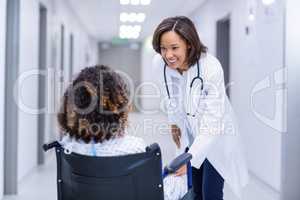 Doctor interacting with female patient in corridor