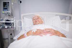 Senior woman patient wearing oxygen mask lying on bed