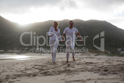 Mature couple running on the beach