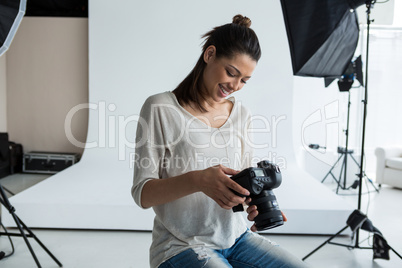 Female photographer reviewing captured photos in her digital camera