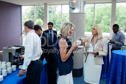 Business executives interacting with each other while having coffee