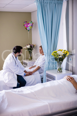 Male doctor consoling female senior patient