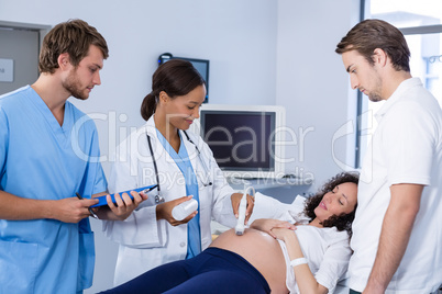 Doctor doing ultrasound scan for pregnant woman