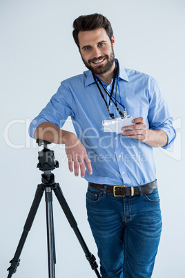 Portrait of male photographer showing identity card