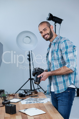 Happy male photographer standing in studio