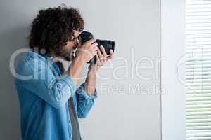 Photographer with digital camera in studio