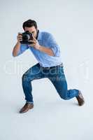 Male photographer with digital camera in studio