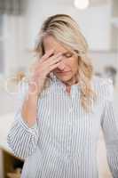 Tense woman with hand on forehead