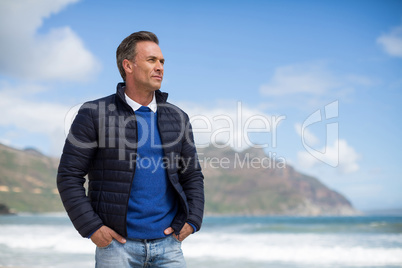 Man standing on the beach looking at ocean
