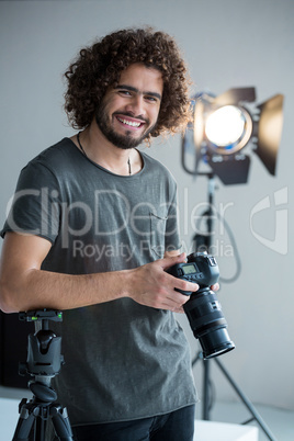 Happy male photographer standing in studio