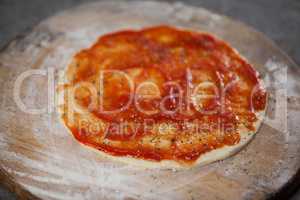 Pizza dough with tomato sauce