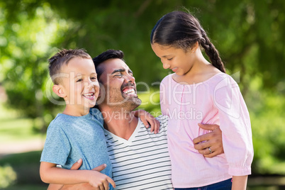Father having fun with his son and daughter in park