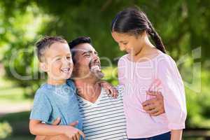 Father having fun with his son and daughter in park