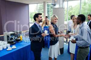 Business executives interacting with each other while having coffee