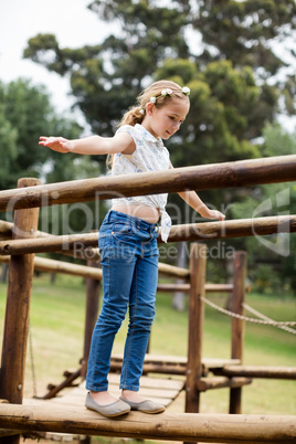 Girl playing on a playground ride in park