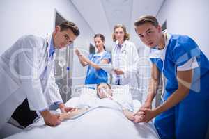 Doctors pushing emergency stretcher bed in corridor