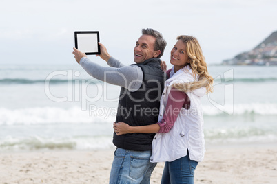 Mature couple taking selfie with digital tablet