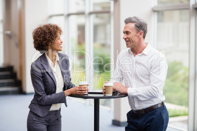 Business executives interacting each other while having coffee