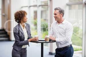 Business executives interacting each other while having coffee