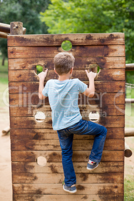 Boy climbing on a playground ride in park