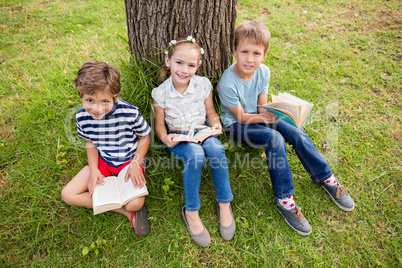Kids reading book in park