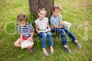 Kids reading book in park