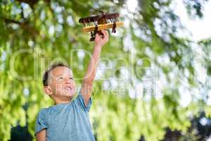 Boy playing with a toy aeroplane in park