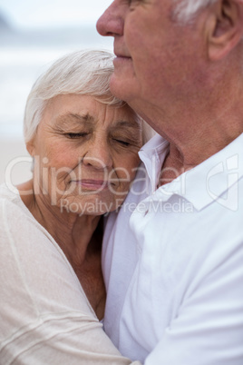 Senior couple embracing each other on the beach