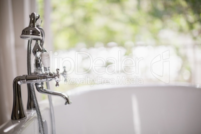 Close-up of tap with bathtub