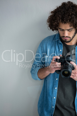 Male photographer reviewing captured photos in her digital camera