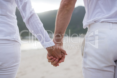 Couple standing with holding hands on the beach