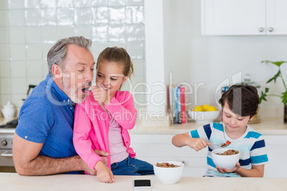 Father and kids having breakfast in kitchen