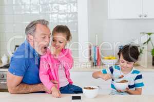 Father and kids having breakfast in kitchen