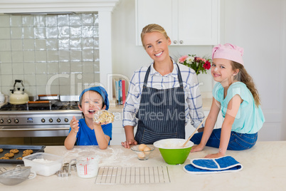 Smiling mother and kids standing in kitchen