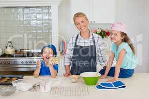 Smiling mother and kids standing in kitchen
