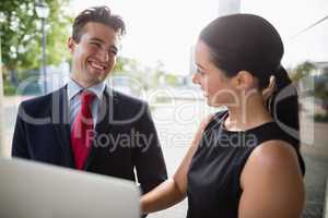 Businessman and colleague discussing over laptop